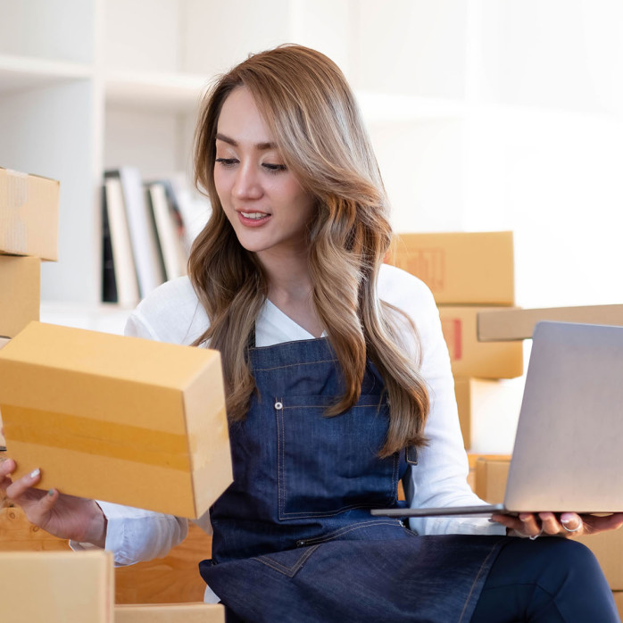 Starting a small business, SME owner, female entrepreneurs are using the rope to tie boxes to pack products Order online to prepare to pack a box of goods for sale to customers, sme business idea