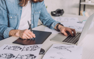 cropped view of animator using gadgets near sketches
